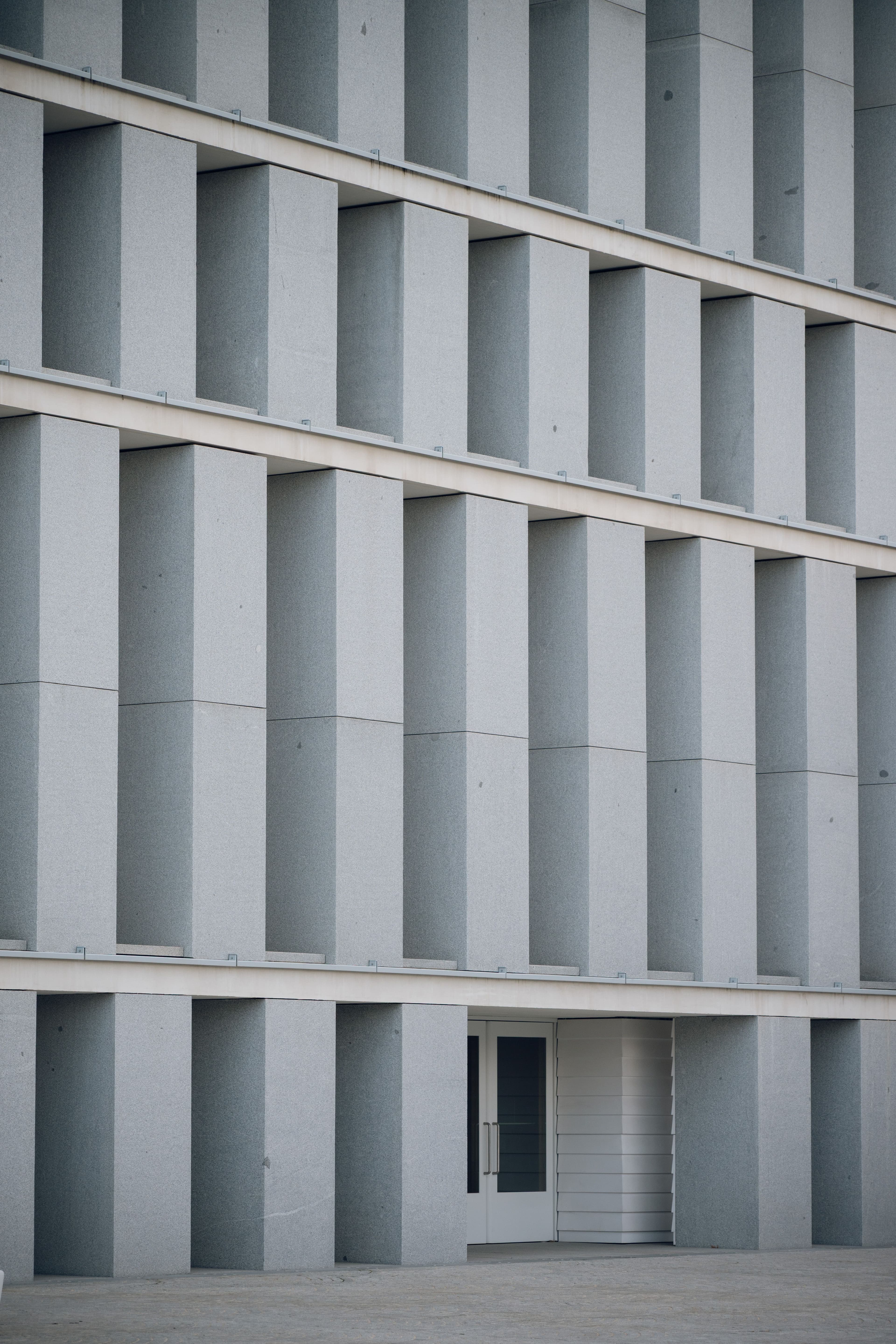 Düşey beton kanatların oluşturduğu ritmik modern yapı cephesi